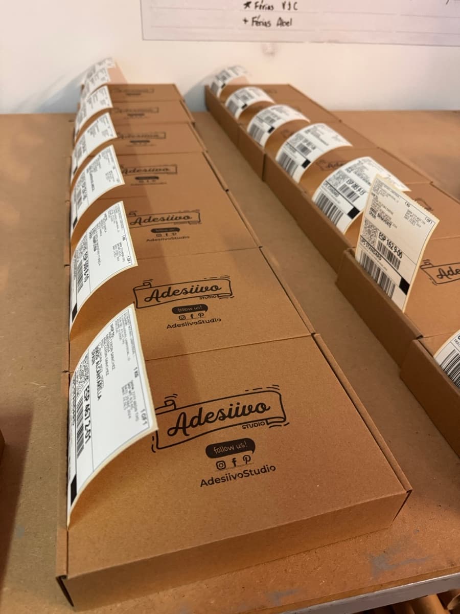 Branded AdesiivoStudio boxes ready for shipping