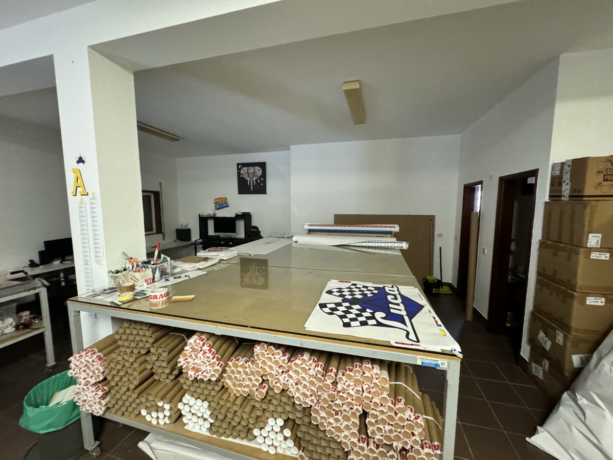El taller de AdesiivoStudio en Porto con mesas de trabajo y tubos de envío