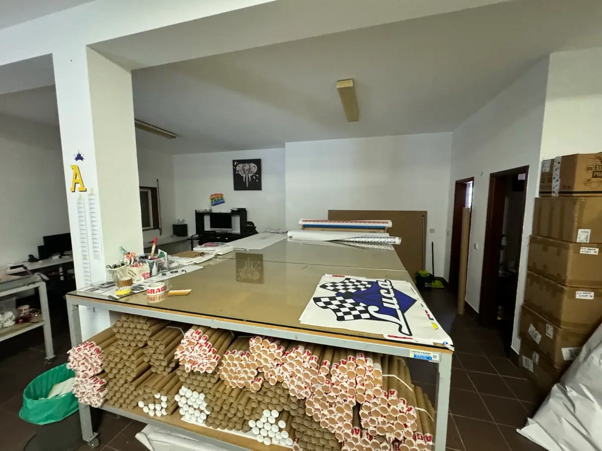 El taller de AdesiivoStudio en Porto con mesas de trabajo y tubos de envío